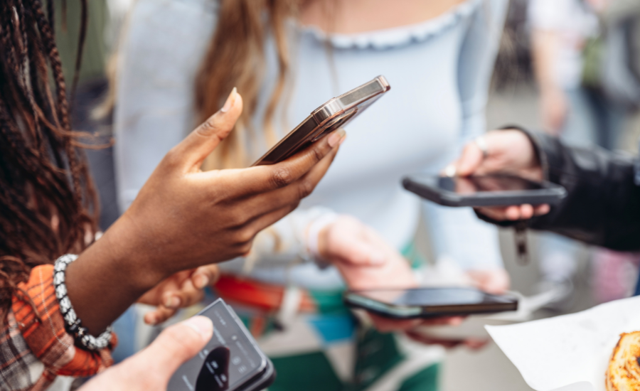 Several people in a group scrolling through socila meida on their phones to connect and share information